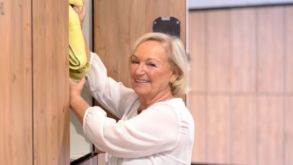 Attractive senior woman reaching into a cupboard